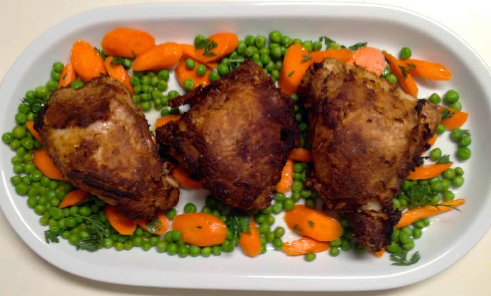Hugh Acheson’s Crispy Chicken Thighs with Peas, Carrots and Hot-Sauce Butter