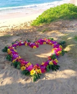 A heart shaped lei is shown on the sands of a beack