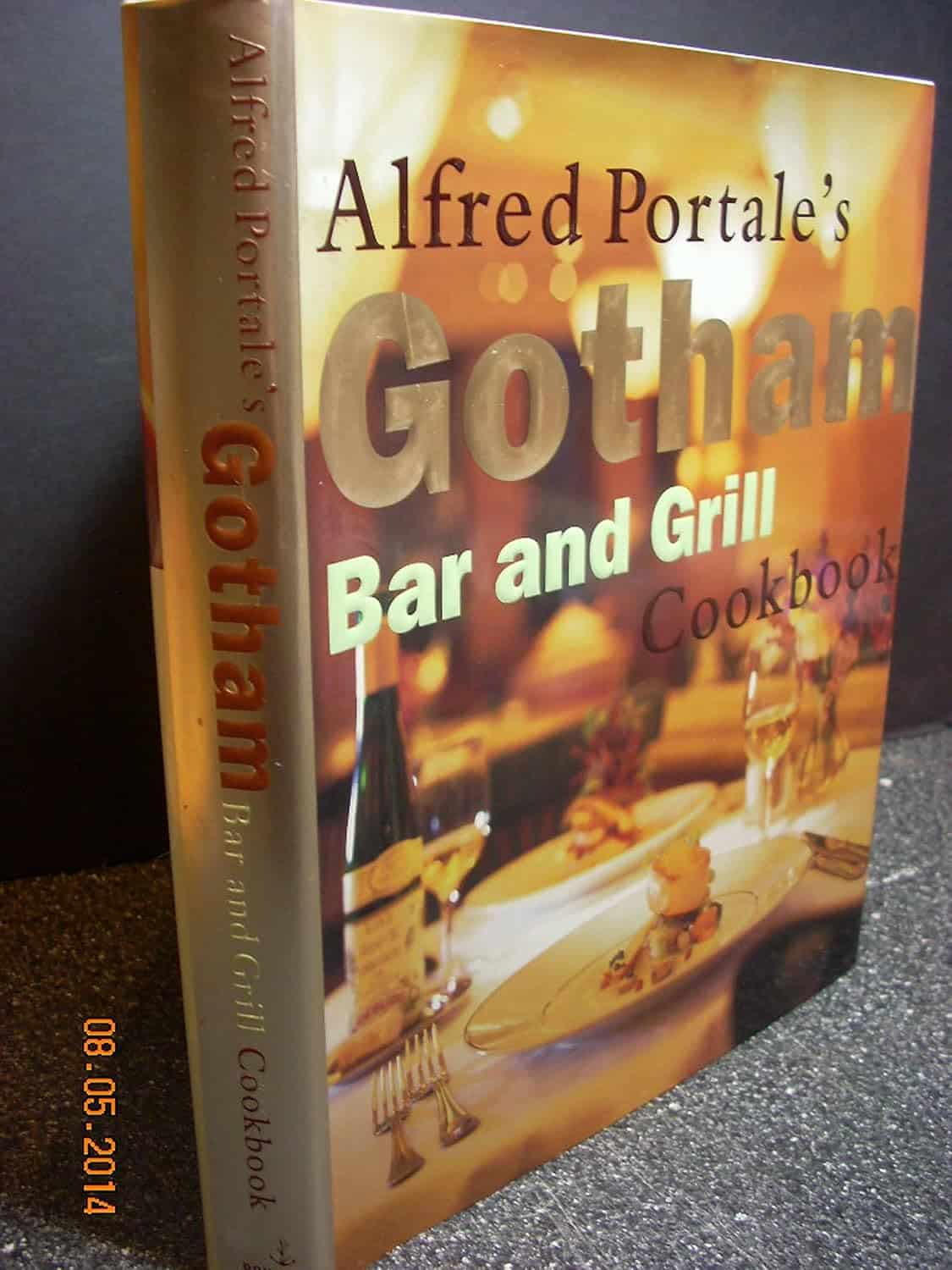 Cover of 'Alfred Portale's Gotham Bar and Grill Cookbook' featuring a dining table scene with wine, glassware, and warm lighting.