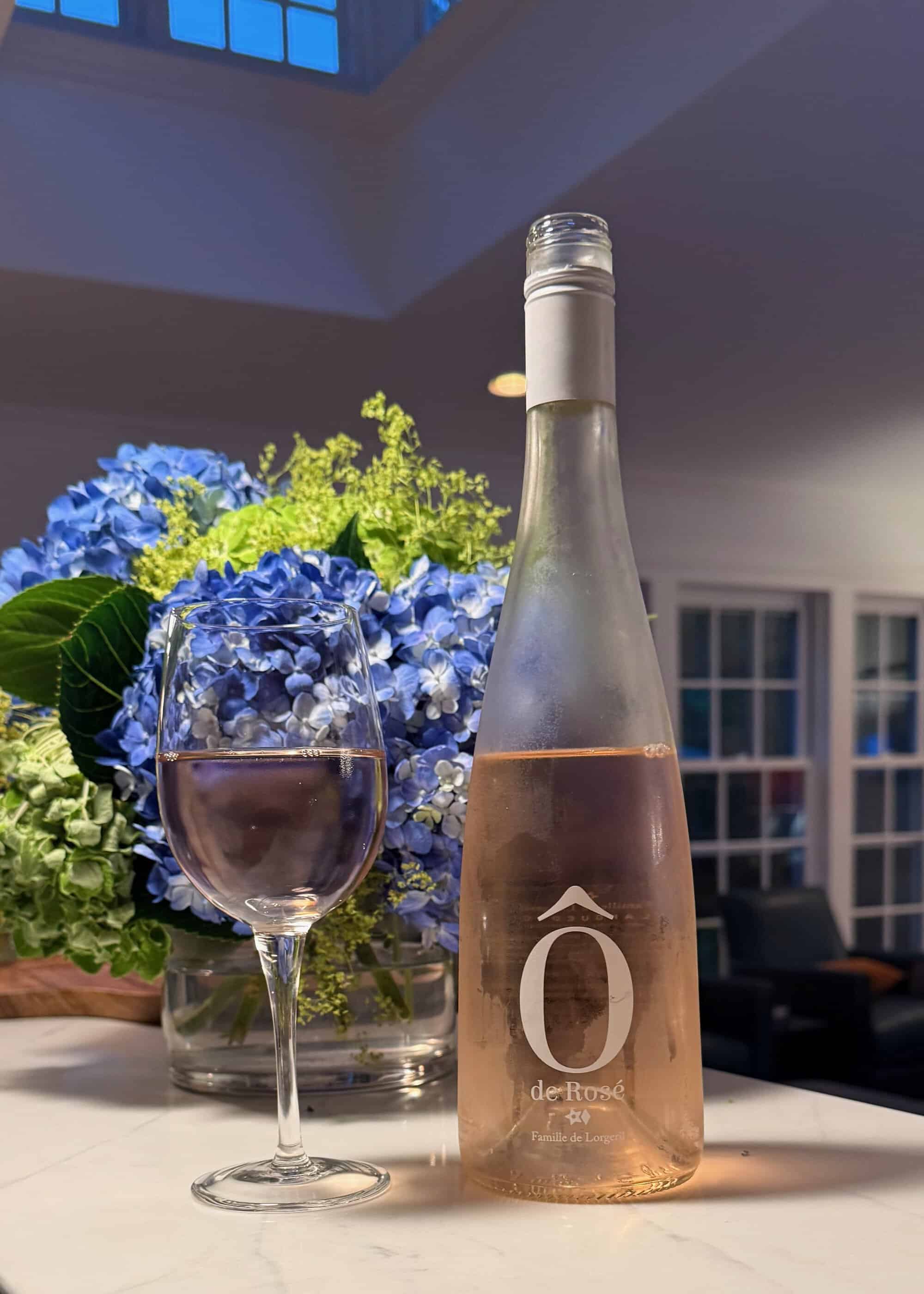 Ô de Rosé bottle with hydrangeas in a garden setting
